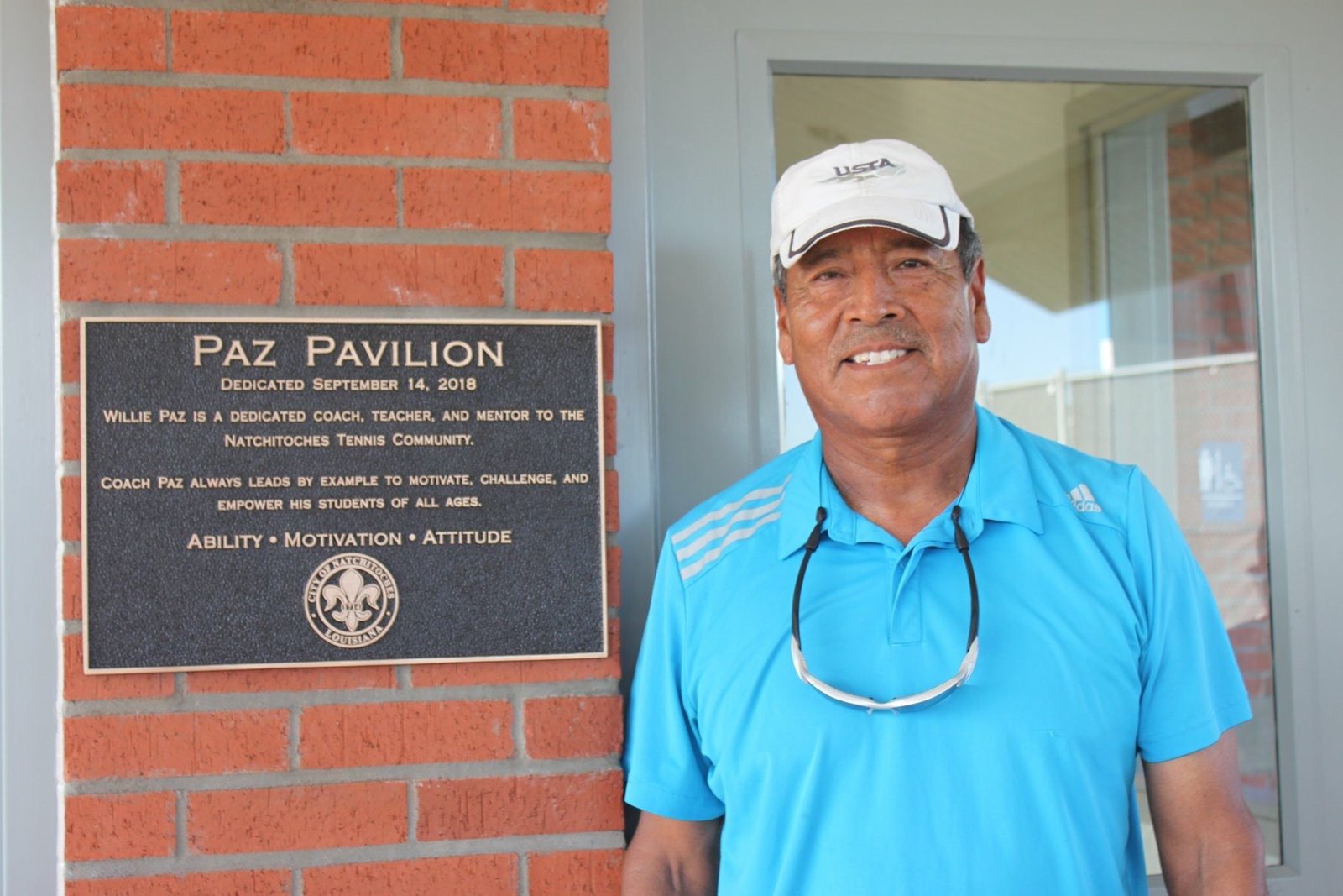 Willie Paz next to Paz Pavillion plaque